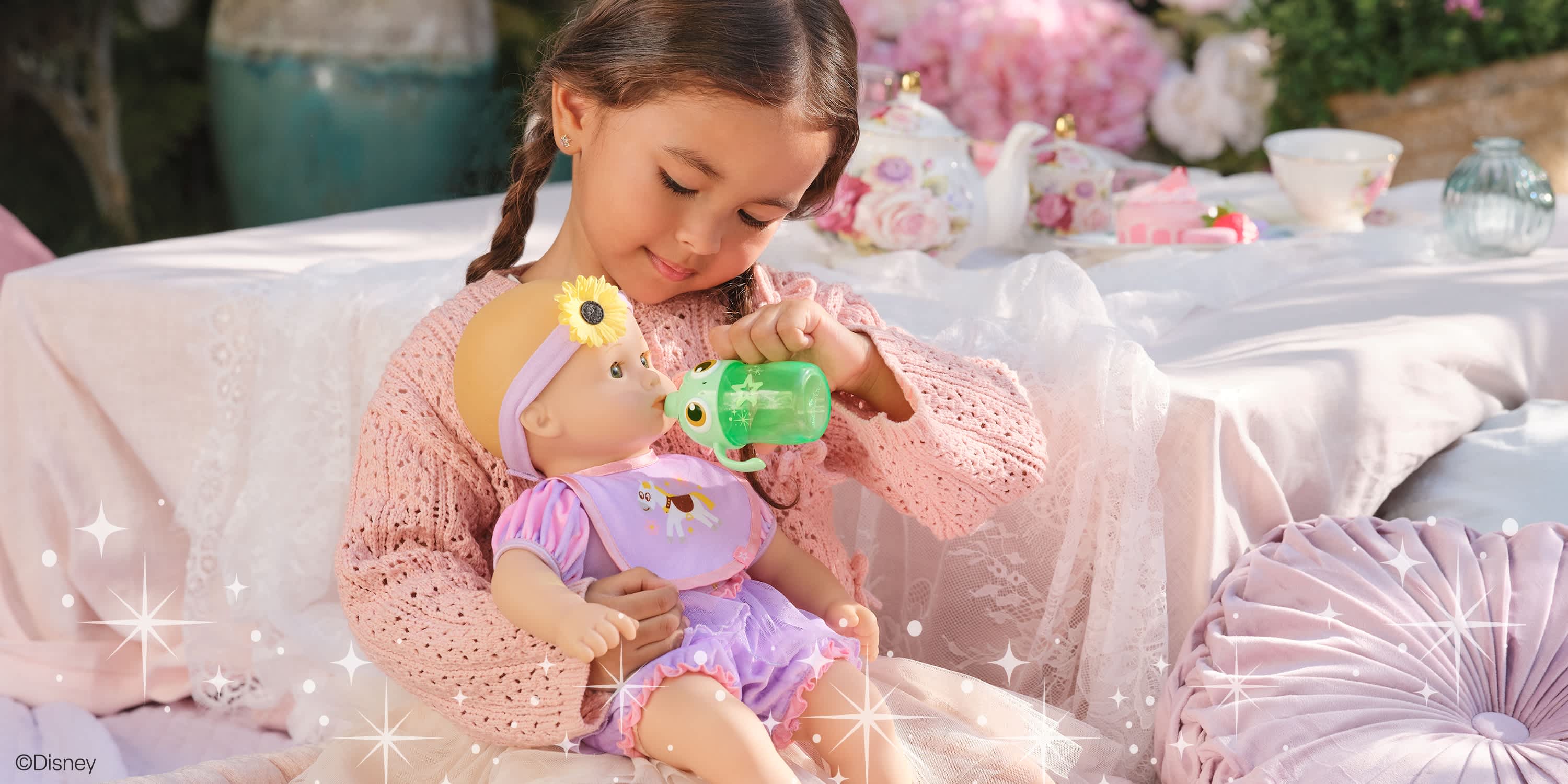 Girl feeding her Bitty Baby x Disney Doll